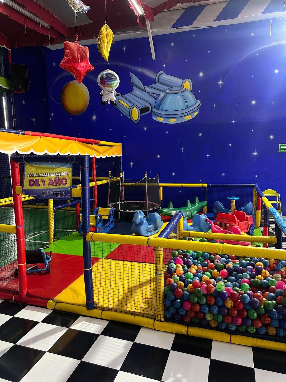 Alberca de pelotas con juegos infantiles y mural de astronauta