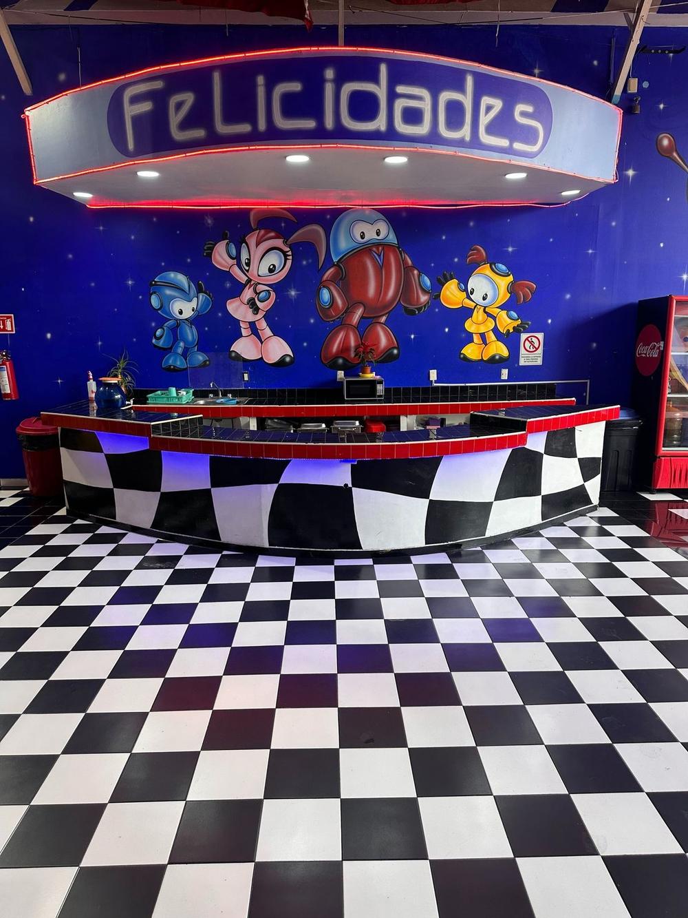 Pista y escenario con letrero de Felicidades y murales espaciales